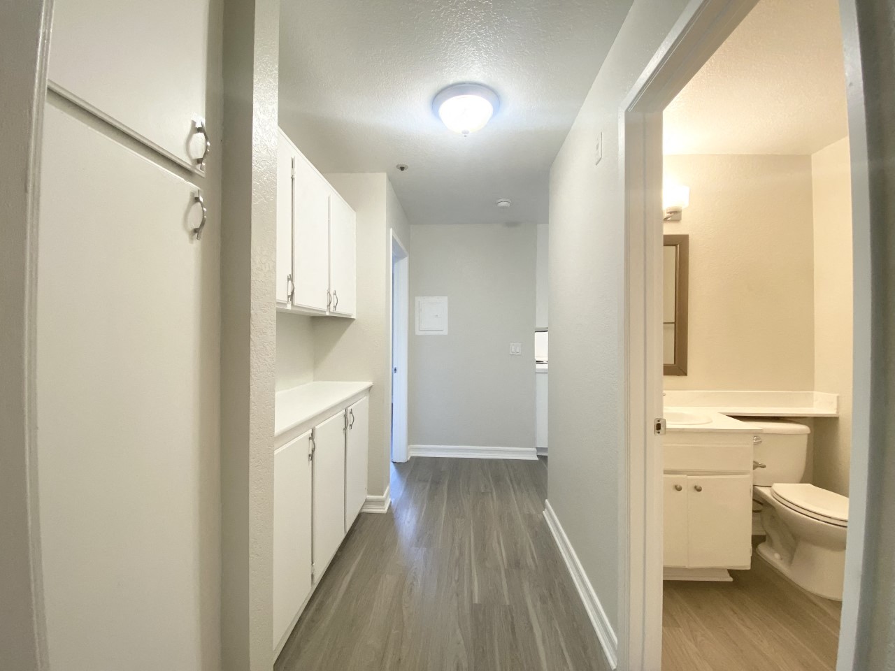 Hallway with view of bathroom and cabinets