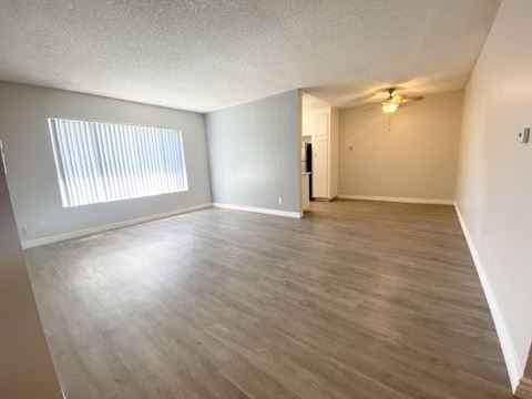 the living room and dining room of an empty apartment
