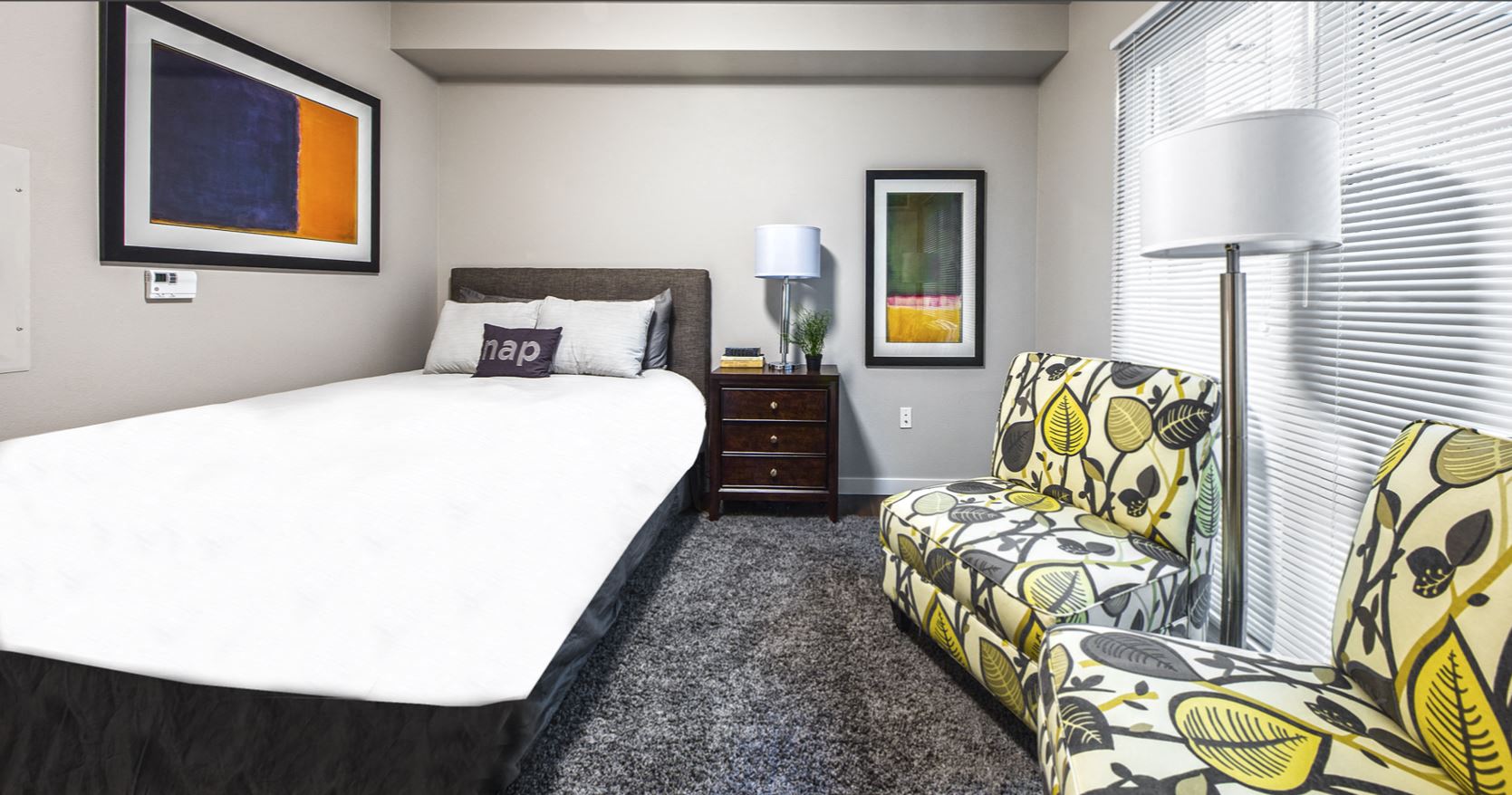 a bedroom with a bed and a chair and a window