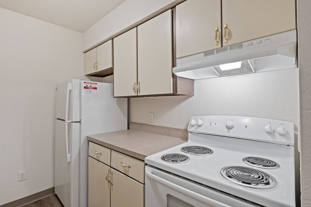 A white stove and refrigerator in a kitchen.