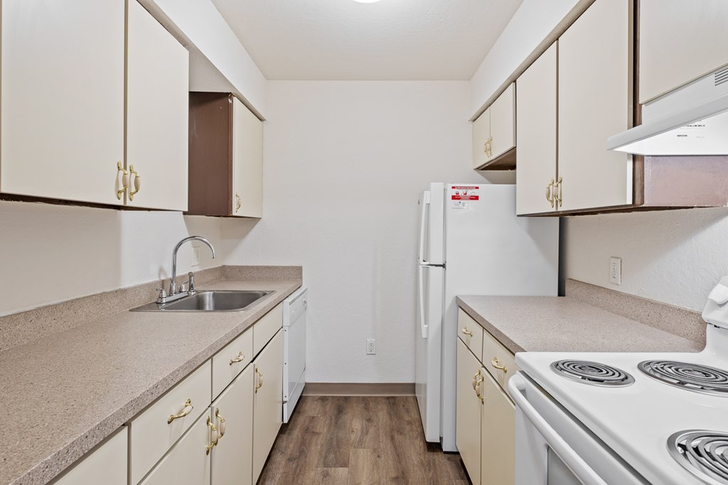 A kitchen with white appliances and beige cabinets.