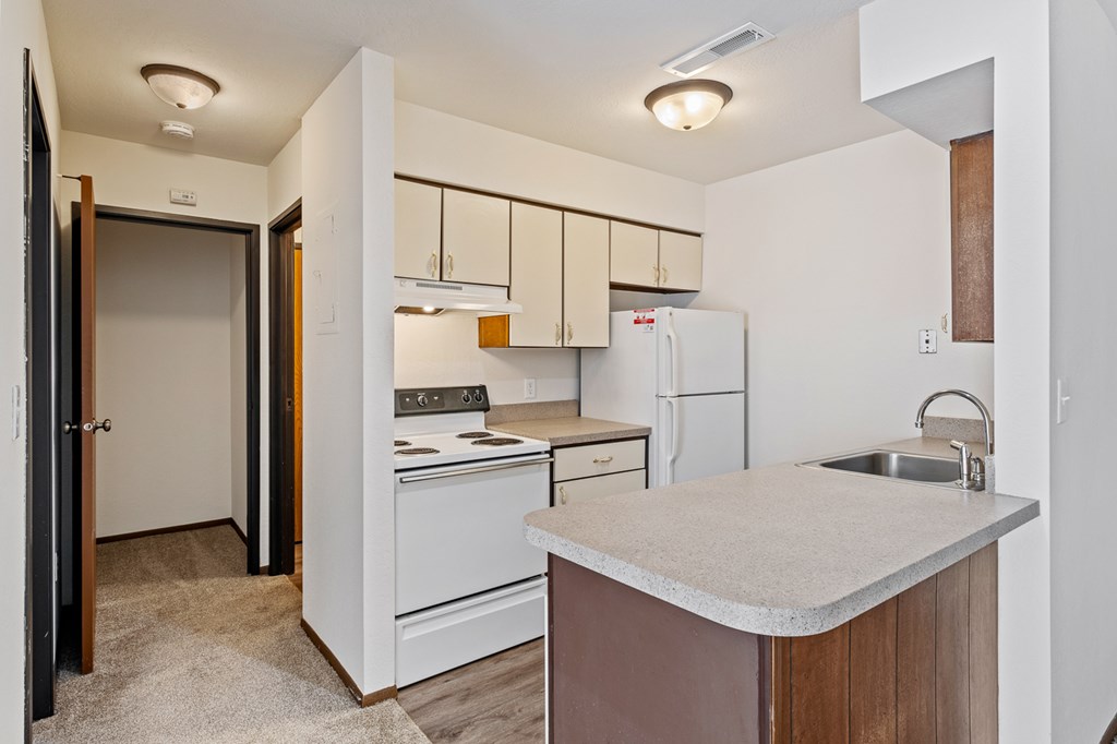 A kitchen with white appliances and a white refrigerator.
