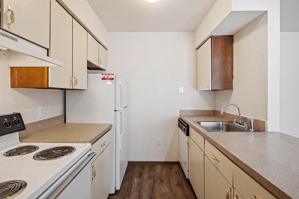 A kitchen with white appliances and wooden cabinets.