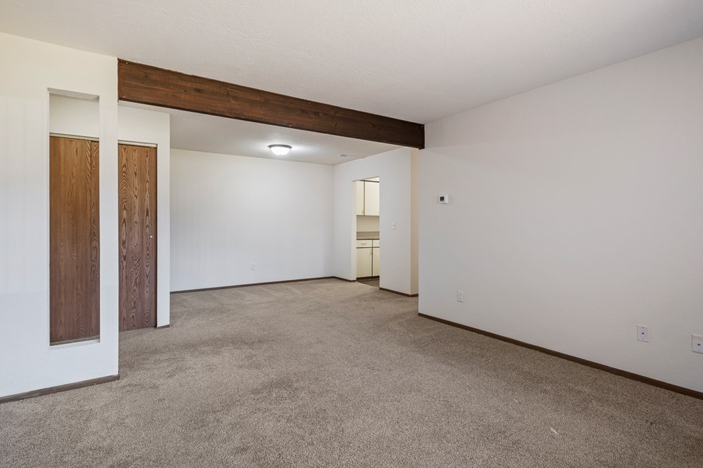 A large empty room with a carpeted floor and white walls.