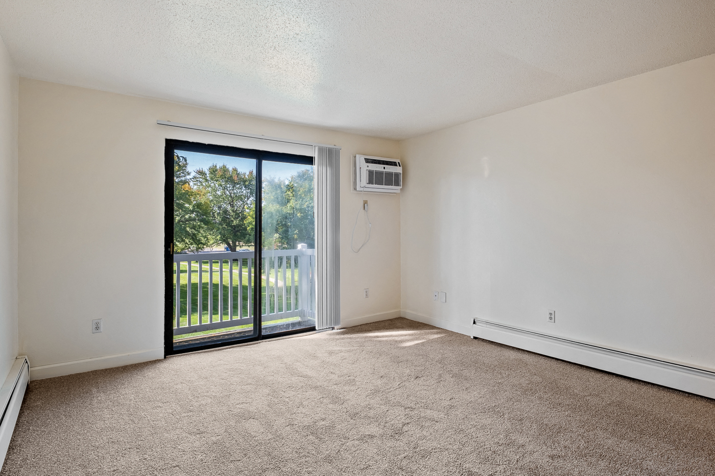 A room with a sliding glass door leading to a backyard.
