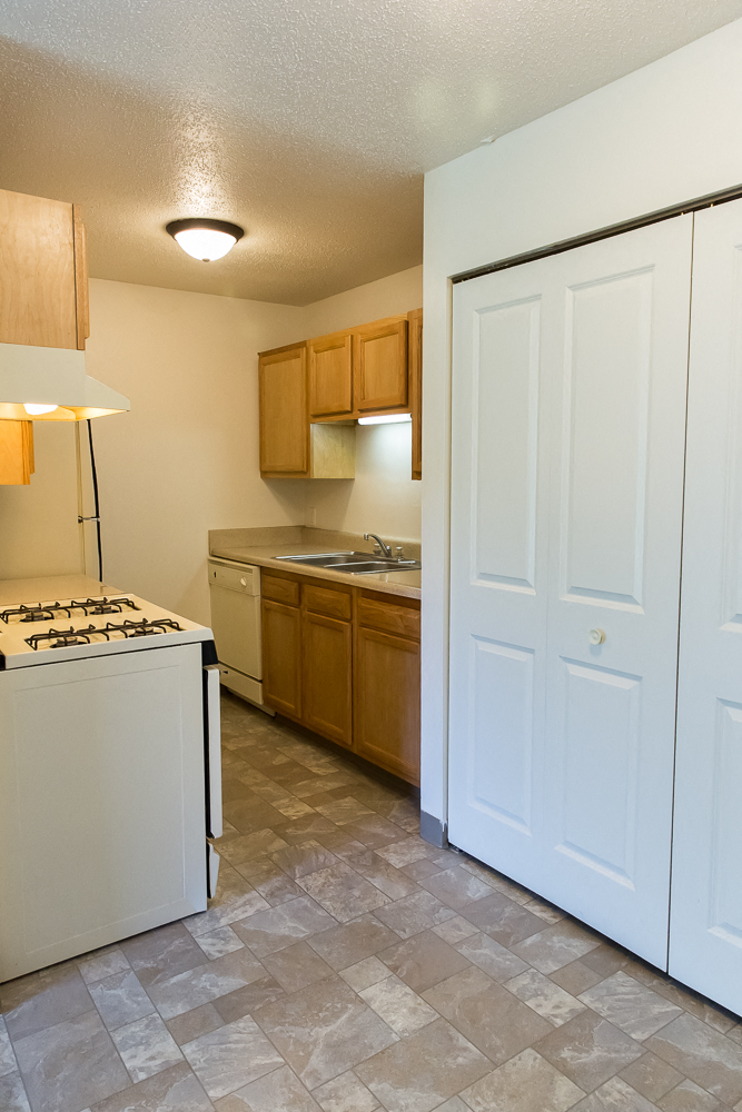 an empty kitchen with a stove and a refrigerator