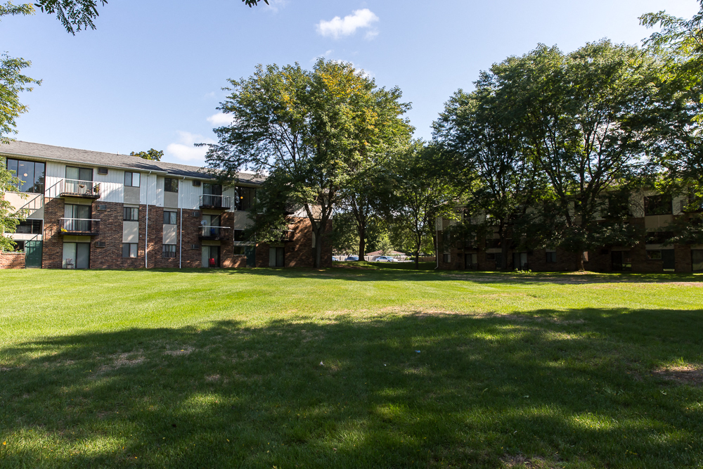 a large green lawn in front of an apartment building
