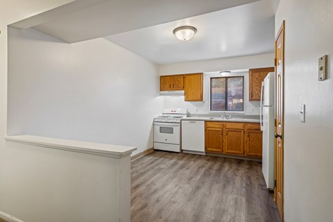 A kitchen with white appliances and wooden cabinets.