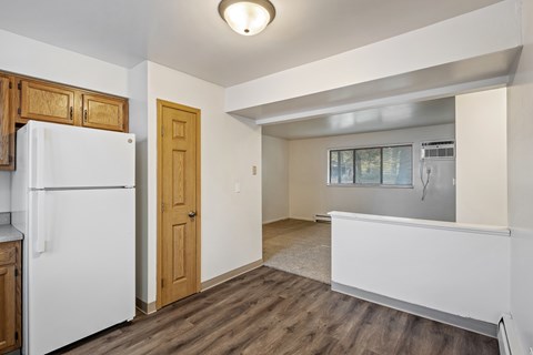A kitchen with a white fridge and wooden cabinets.