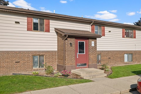 A house with a red door and brown roof.