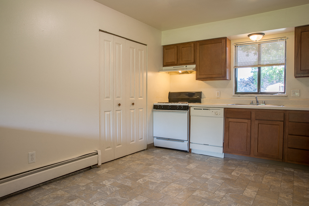a kitchen with white appliances and wooden cabinets