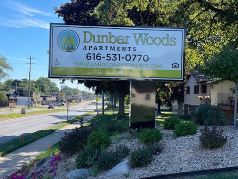 a sign for dunker woods apartments on the side of a street