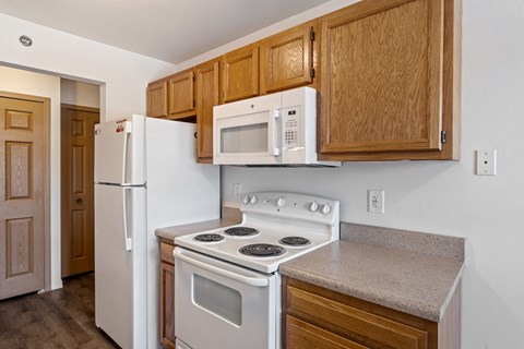 A kitchen with a white stove and microwave above it.