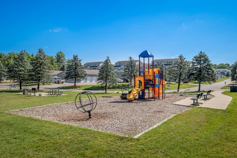 A playground with a yellow slide and a blue and yellow tower.