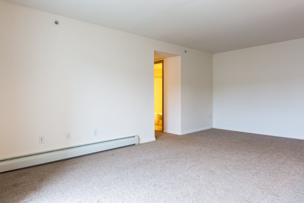 an empty living room with white walls and carpet