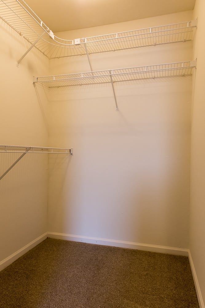 a empty closet in a room with a carpet and white walls