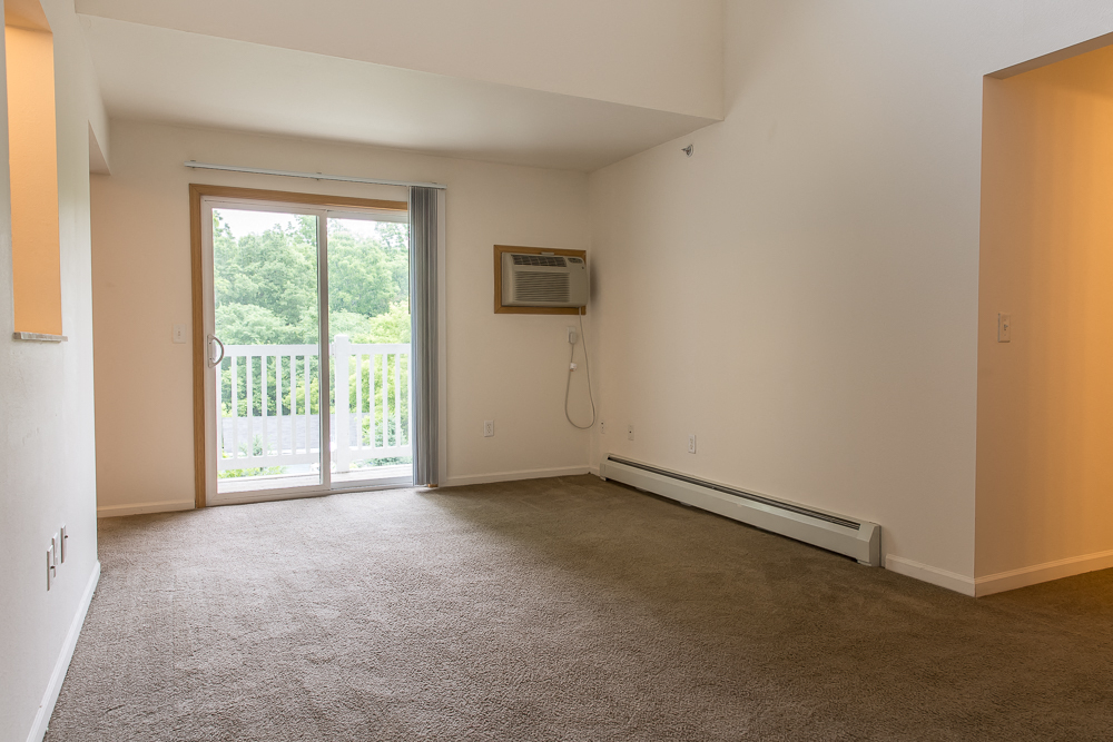 an empty living room with a door to a balcony