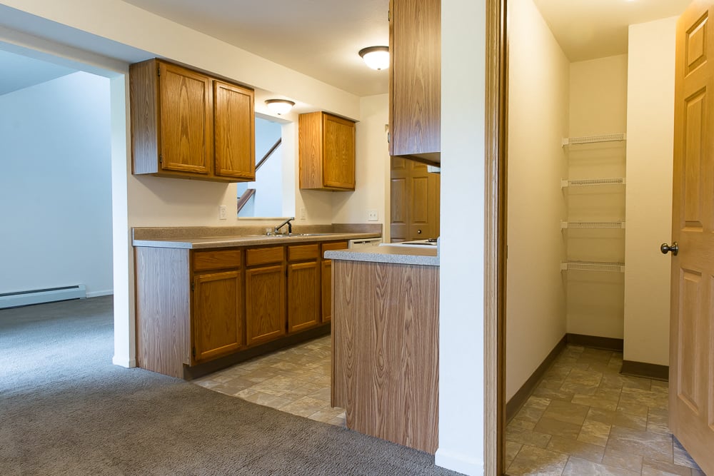 an empty kitchen with wooden cabinets and a sink