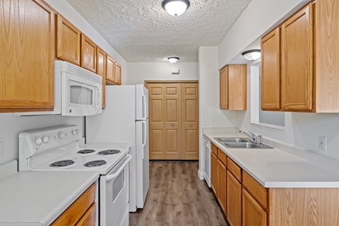 A kitchen with wooden cabinets and white appliances.