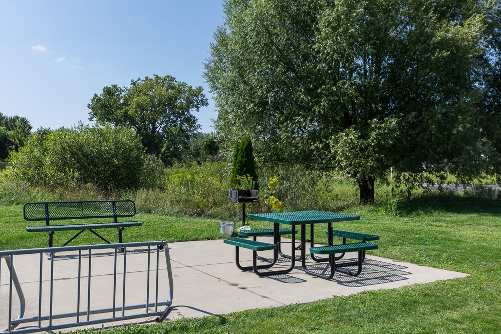 a picnic area with two picnic tables in a park