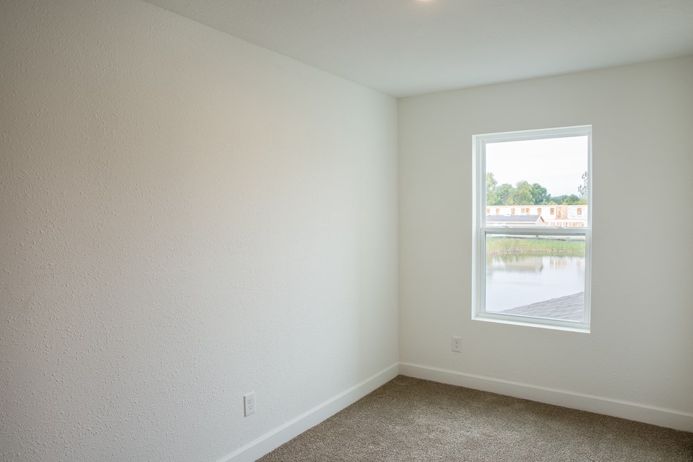 an empty room with a window overlooking a river