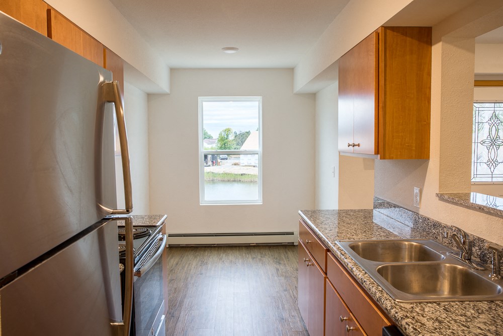an empty kitchen with granite counter tops and stainless steel appliances