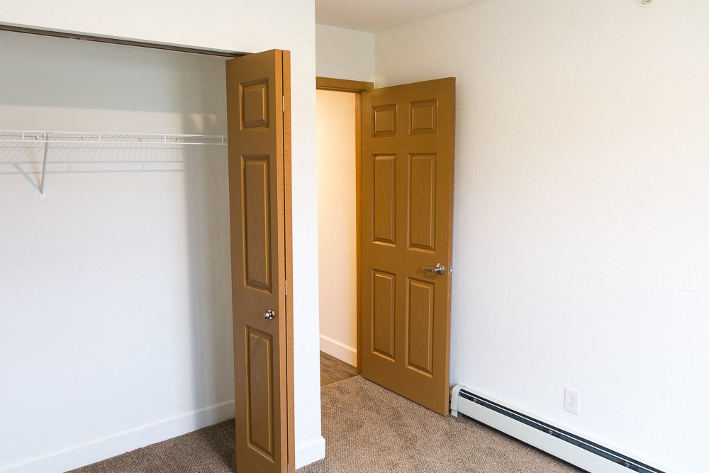 an empty room with two doors and a closet