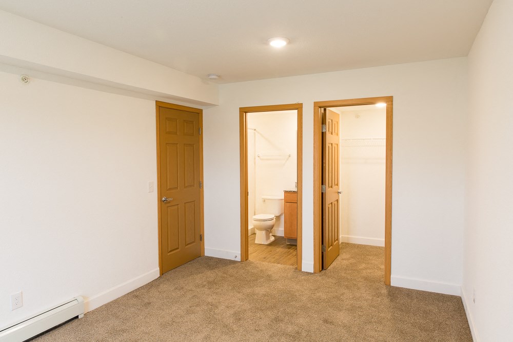 a living room with a door to a bathroom and a toilet