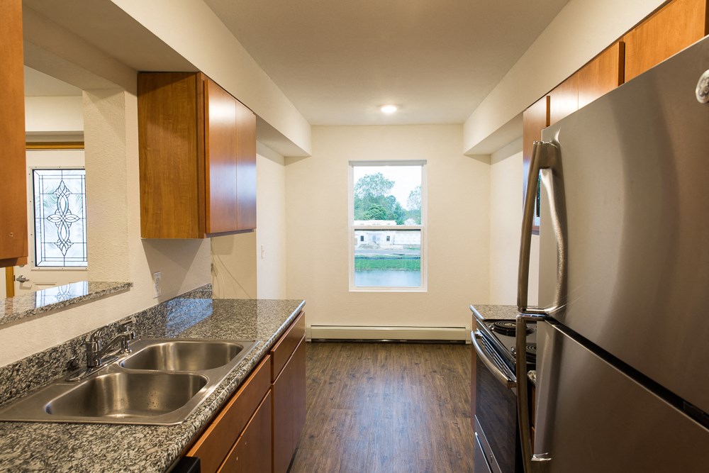full kitchen with granite counter tops and stainless steel appliances and a window