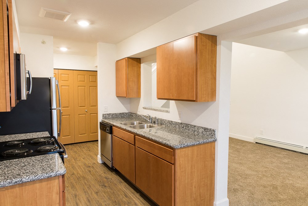 a kitchen with wood cabinets and granite counter tops and a black stove