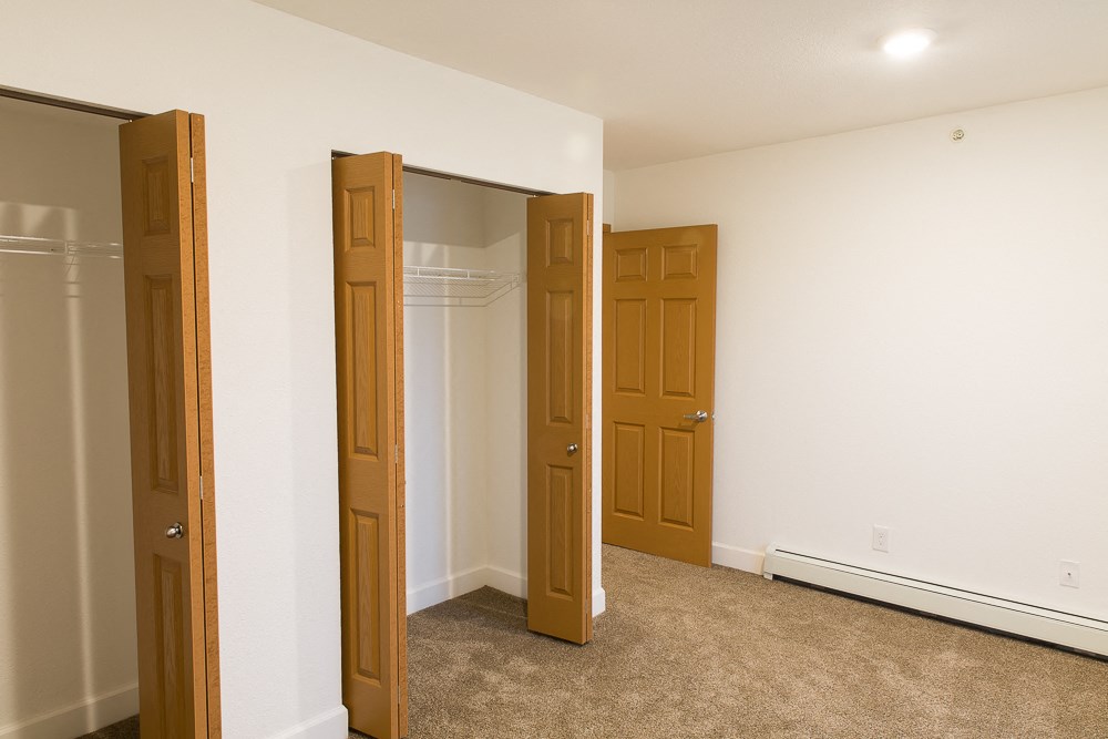 a bedroom with three doors and a carpeted floor