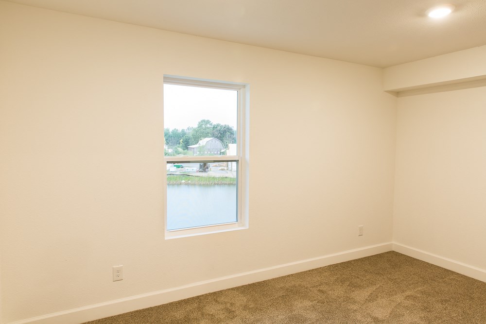 an empty room with a window overlooking a lake
