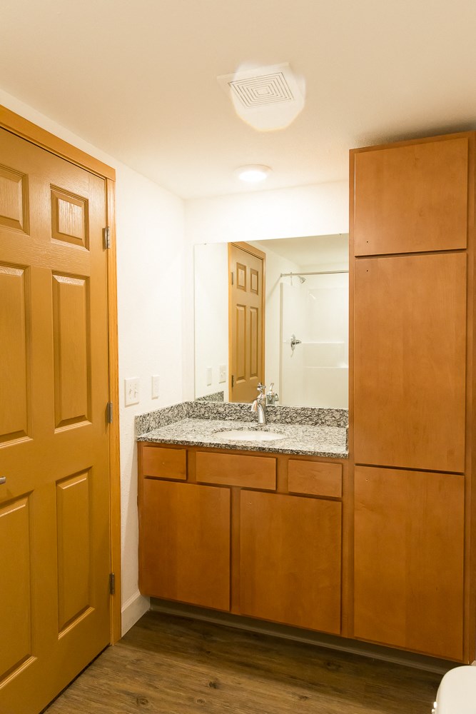 an empty bathroom with a sink and a wooden door