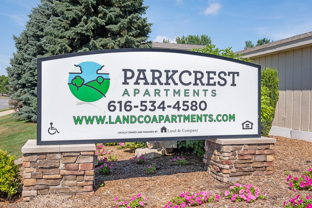 A sign for Parkcrest Apartments is displayed in front of a building.