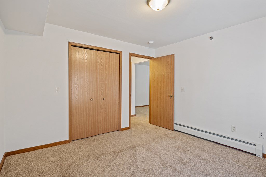 A room with two doors and a carpeted floor.
