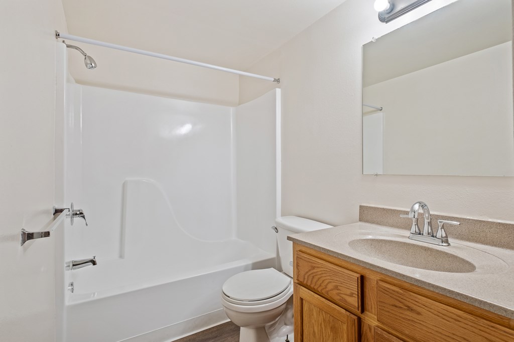 A white bathroom with a toilet, sink, and bathtub.