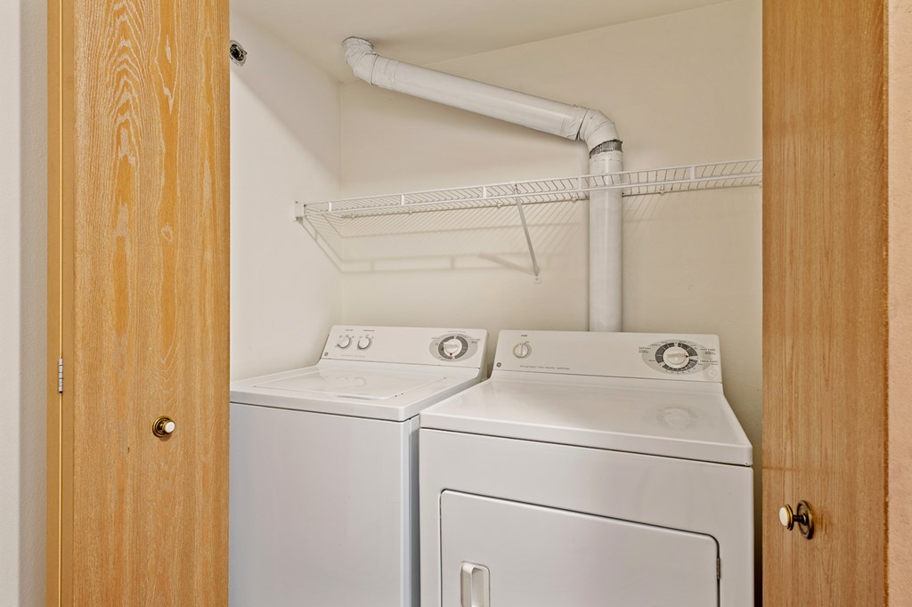 A white washing machine and dryer in a small laundry room.