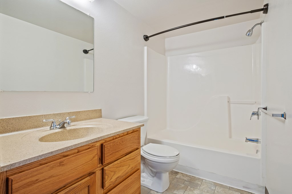 A bathroom with a sink, toilet, and bathtub.