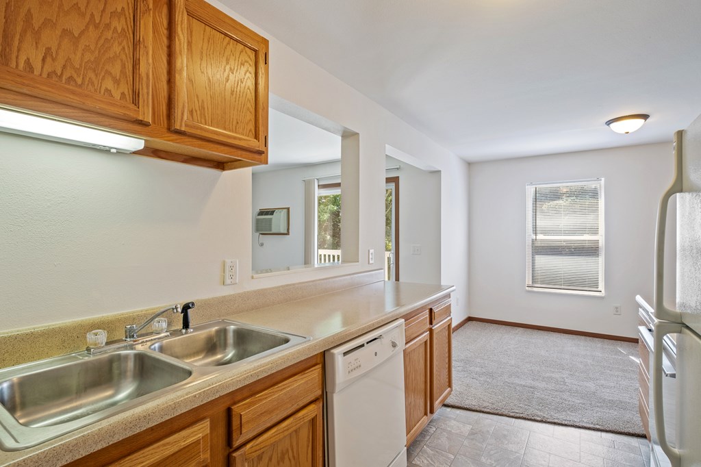 A kitchen with wooden cabinets and a stainless steel sink.
