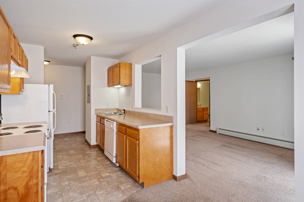 A kitchen with wooden cabinets and a white refrigerator.