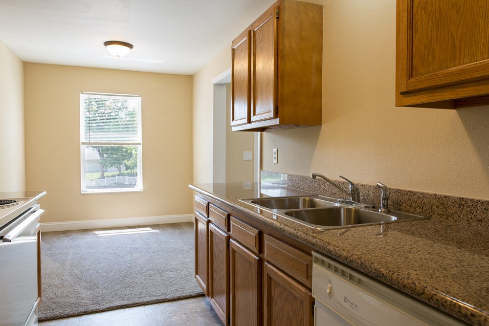 an empty kitchen with a sink and a window