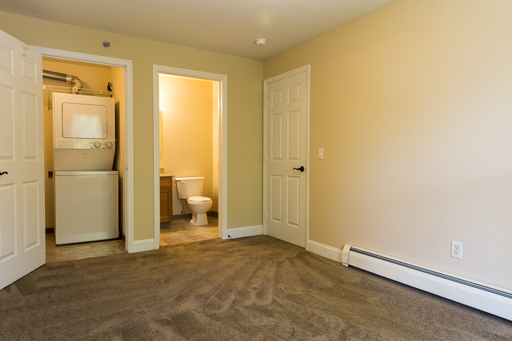 a laundry room with a washer and dryer and a door to a bathroom