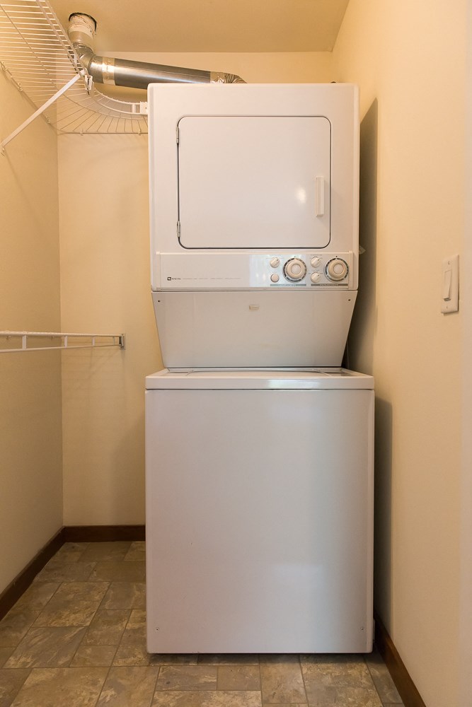 a washer and dryer are stacked on top of a refrigerator