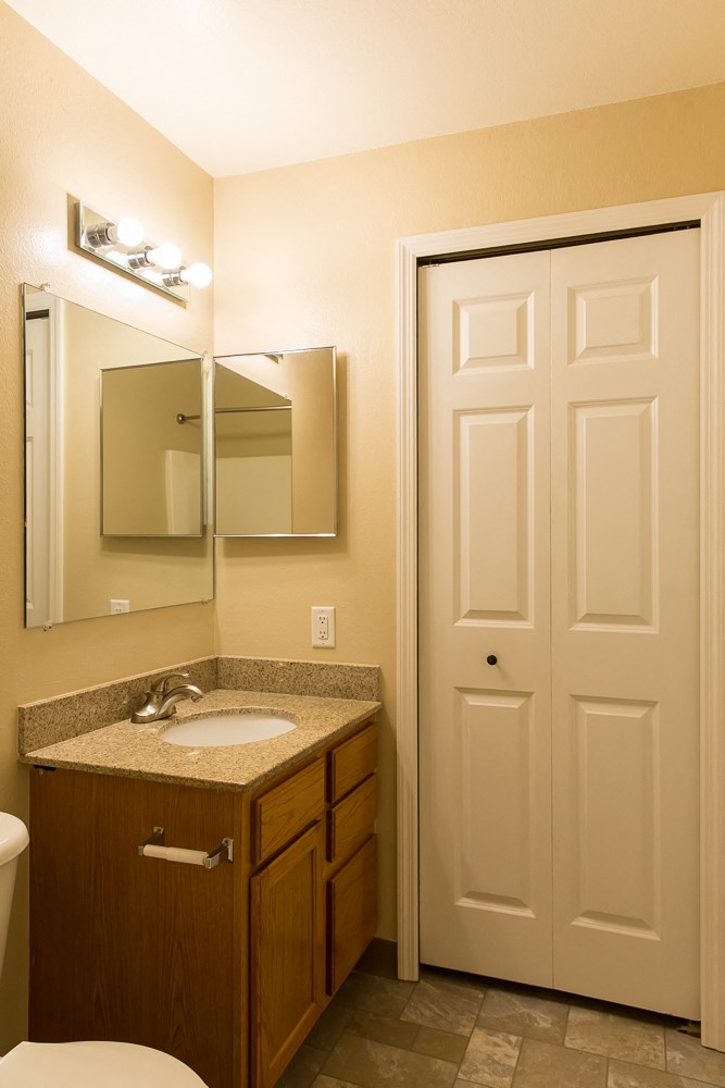 a bathroom with a sink and a mirror and a door