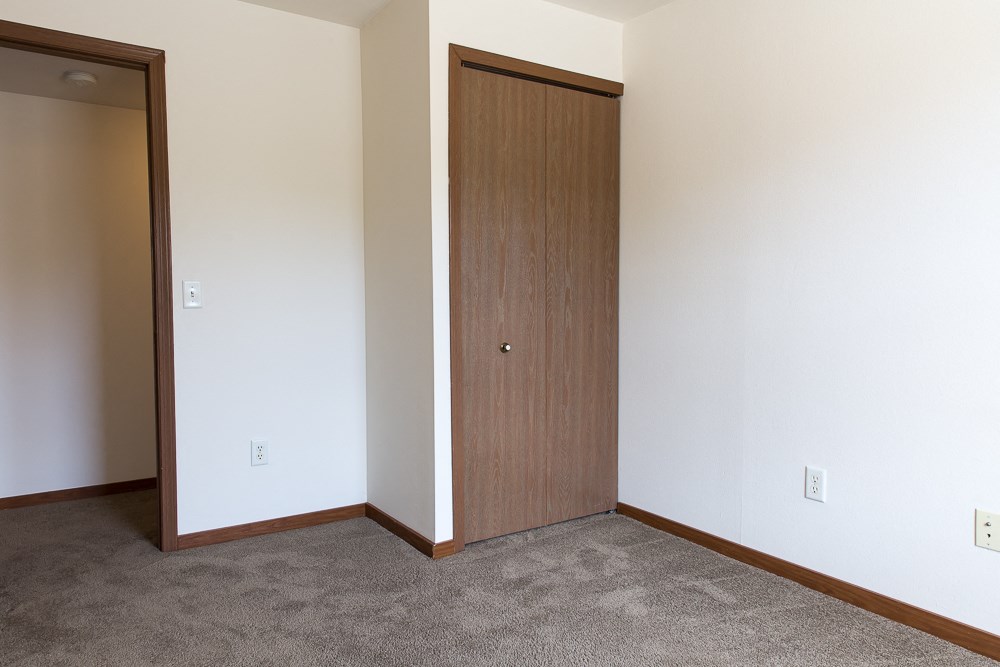 an empty room with a door to a closet