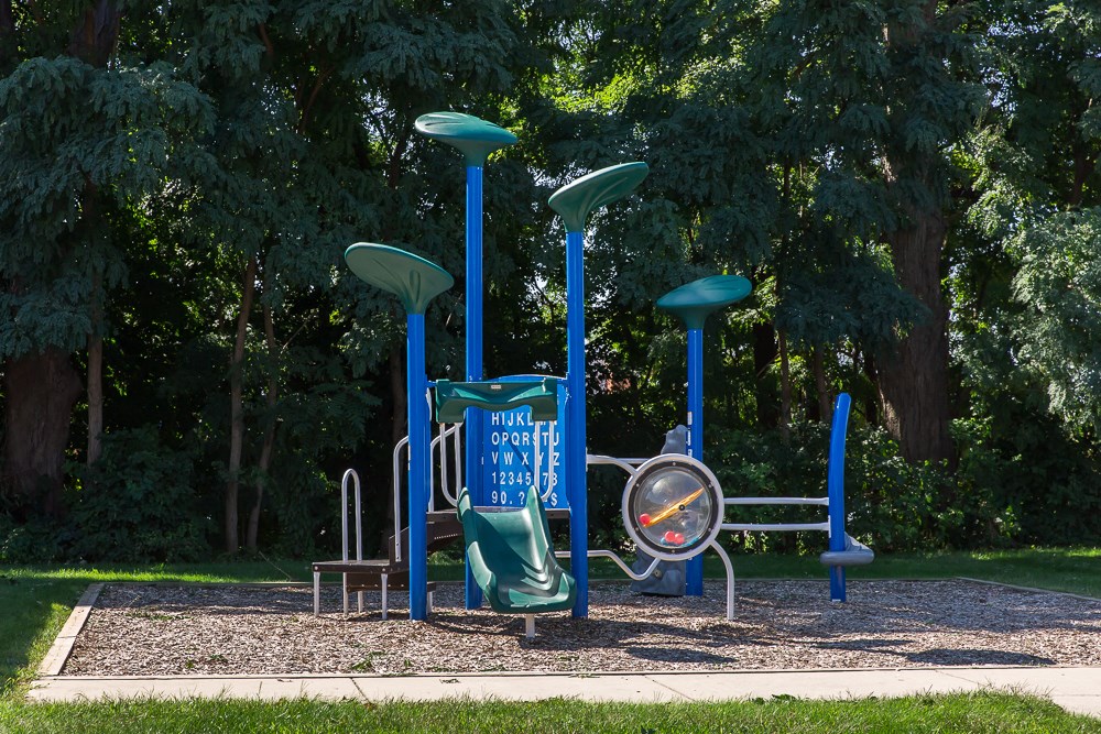 a playground with a blue swing set in a park