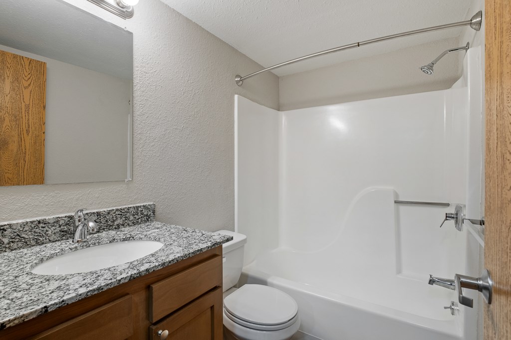 A white bathroom with a sink, toilet, and bathtub.