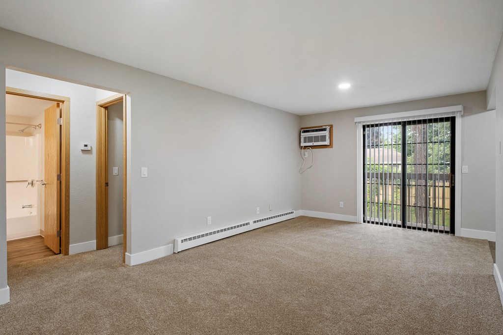 A room with a sliding glass door leading to a balcony.