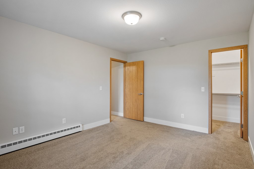 A room with a carpeted floor and a door.
