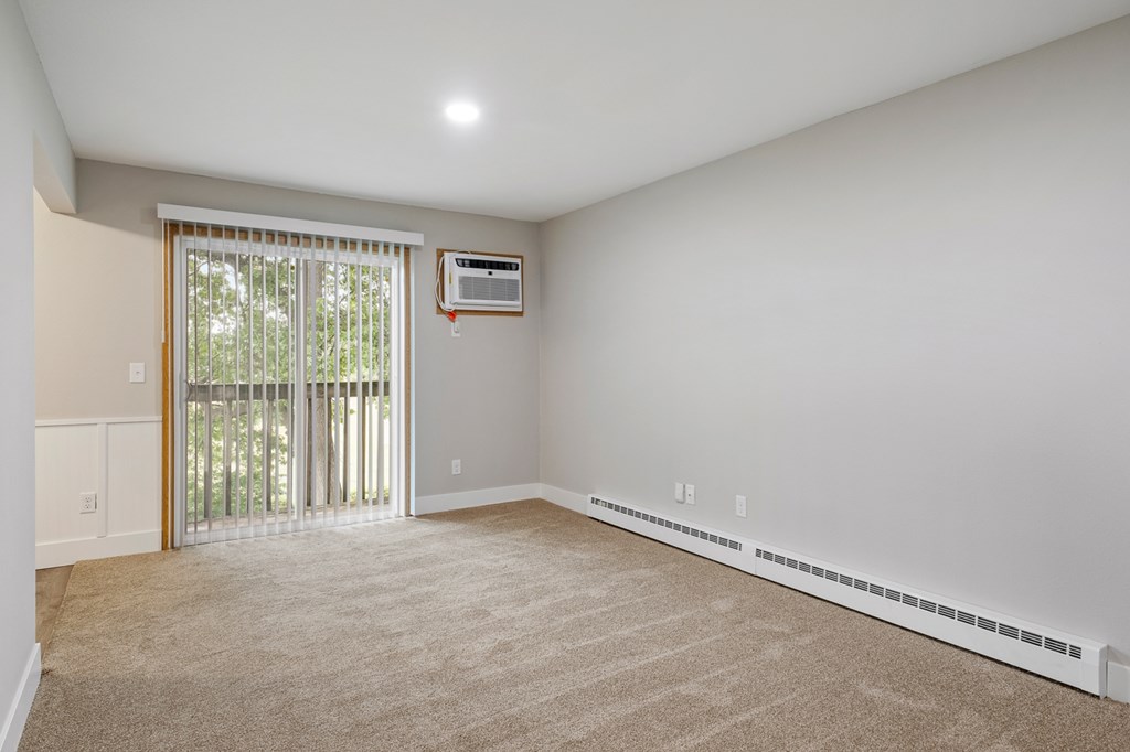 A room with a sliding glass door leading to a balcony.